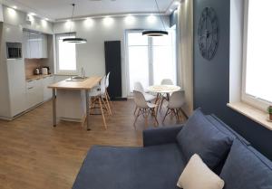 盧布林的住宿－Diamentowe Wzgórze 26/3，客厅配有蓝色的沙发和桌子