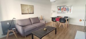 un soggiorno con divano e tavolo di apartment 50m from historic town 5min Beach Palais Croisette - Free private parking a Cannes