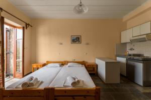 a bedroom with a large bed with towels on it at KASTRO AGGELIKI in Kardamyli