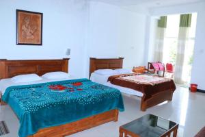 A bed or beds in a room at Wathsala Inn