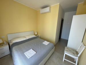 ein kleines Schlafzimmer mit einem Bett und einem Stuhl in der Unterkunft B&B Le Rose in Porto San Giorgio