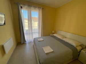 ein Schlafzimmer mit einem Bett und einem großen Fenster in der Unterkunft B&B Le Rose in Porto San Giorgio