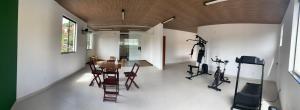 a room with a gym with a table and exercise bikes at Pecafe Hotel in Manhuaçu