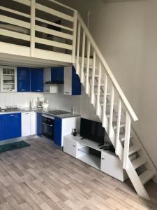 a kitchen with blue cabinets and a white staircase at Résidence MARINA 3 in Les Trois-Îlets