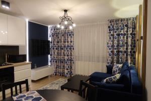 a living room with a blue couch and a kitchen at Amart in Gdańsk