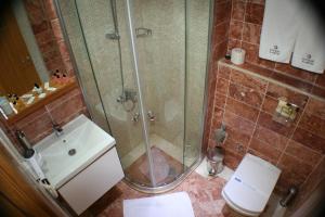 a bathroom with a shower and a toilet and a sink at Cunda Kivrak Hotel in Ayvalık