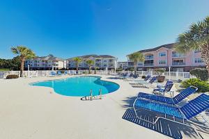 una piscina con sillas azules y palmeras en Tranquil 3BR Condo in Magnolia Pointe near Myrtlewood Golf Resort, en Myrtle Beach