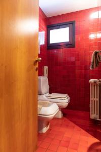 a bathroom with a toilet and a red tiled wall at Hotel Due Mori in Cittadella