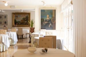 a dining room with tables and a painting on the wall at Hotel Due Mori in Cittadella