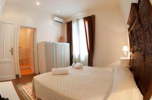 1 dormitorio con 1 cama con 2 toallas en B&B Belveliero - Il Capitano, en Trapani