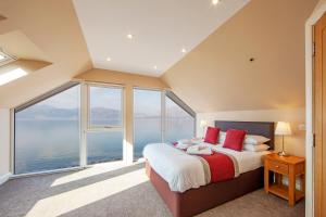 
a bedroom with a bed and a window at Beach Houses with Hot Tubs in Glencoe

