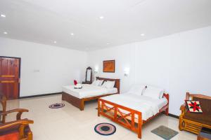 A bed or beds in a room at Wathsala Inn