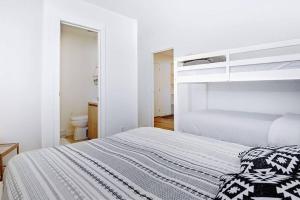 - une chambre blanche avec un lit et des toilettes dans l'établissement 106 Chemin des Ruisselets, à Stoneham