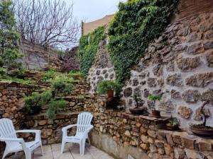 dos sillas blancas sentadas junto a una pared de piedra en Casitapados, en Torres