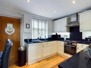 a kitchen with white cabinets and a black counter top at THE VIEW! in Delph