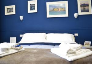 a bedroom with blue walls and a bed with towels at Il Viaggio di Dante Historical Center in Naples