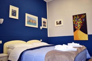 a blue bedroom with a bed with towels on it at Il Viaggio di Dante Historical Center in Naples