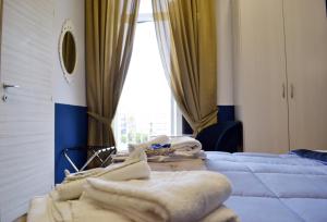 a room with two beds with towels on them at Il Viaggio di Dante Historical Center in Naples