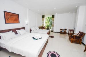 a hotel room with two beds and a living room at Wathsala Inn in Nallathanniya