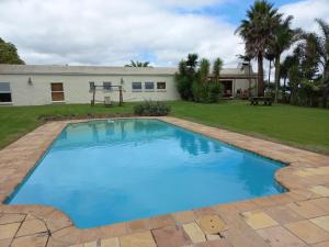 a large blue swimming pool in front of a house at Esperanza Countryside Accomodation in George