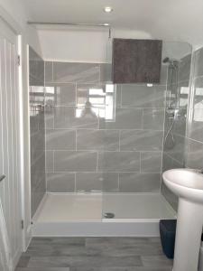 a bathroom with a shower with a toilet and a sink at Carriage Lodge - Stunning Apartment with parking in Wateringbury