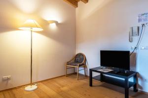 a room with a desk with a television and a lamp at Ferienparadies Sabina Lärche in Alpe di Siusi