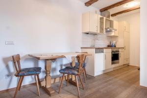 a small kitchen with a wooden table and chairs at Ferienparadies Sabina Compatsch in Alpe di Siusi