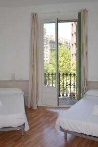 a bedroom with two beds and a large window at Claris Apartments in Barcelona
