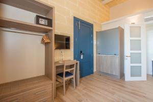 a room with a blue door and a desk at Georges Boutique Living in Xagħra