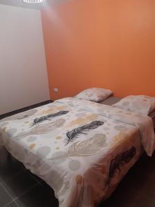 Una cama con edredón en una habitación en Orisha, en Cayenne
