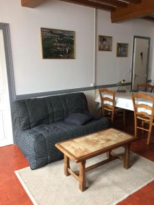 ein Wohnzimmer mit einem Sofa und einem Tisch in der Unterkunft La maison de Jeannot in Aisy-sous-Thil