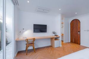 a room with a desk with a tv and a chair at Casa 33 Hatyai in Hat Yai