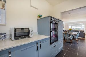 uma cozinha com um balcão com um micro-ondas e uma mesa em Bryn Derw em Caernarfon