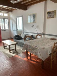 a living room with a table and a couch at La maison de Jeannot in Aisy-sous-Thil +9 photos