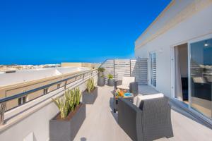a balcony with chairs and plants on a building at Georges Boutique Living in Xagħra