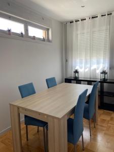 a dining room with a wooden table and blue chairs at House T3 in Vila Nova de Gaia