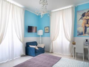 Habitación azul con silla azul y escritorio. en Affittacamere Golfo Della Luna, en La Spezia