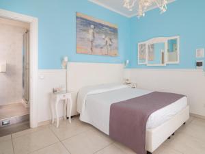 ラ・スペツィアにあるアフィッタカメレ ゴルフォ デラ ルナのベッドルーム1室(ベッド1台付)が備わります。壁には絵画が飾られています。