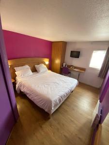 1 dormitorio con 1 cama blanca grande y pared morada en Hôtel De La Plage, en Calais