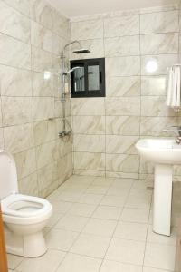 La salle de bains est pourvue de toilettes et d'un lavabo. dans l'établissement HOTEL LAVAL, à Abidjan