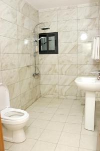 a bathroom with a toilet and a sink at HOTEL LAVAL in Abidjan