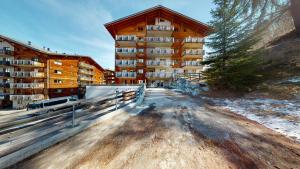 an apartment building with a fence in front of it at Pracondu 2 305 - OUTDOOR & FUN charming apartment in Nendaz