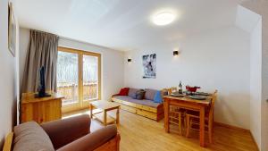 a living room with a couch and a table at Pracondu 2 305 - OUTDOOR & FUN charming apartment in Nendaz
