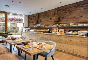 um restaurante com paredes e mesas e cadeiras de madeira em Vetta Alpine Relax em Livigno