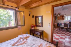 a bedroom with a bed and a dining room at Dreamy Wooden Cottage Lixouri in Lixouri