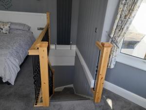 a bedroom with a bunk bed and a stair case at Eddystone Light Apartment in Mevagissey