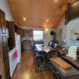 a kitchen and living room with a table and a couch at The Deer Lake Loft in Deer Lake