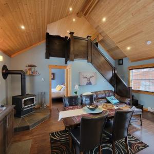 a living room with a table and a wood stove at The Deer Lake Loft in Deer Lake