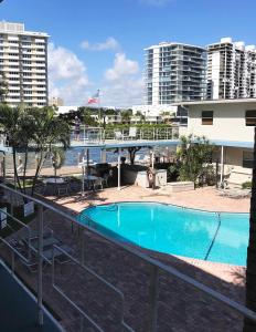 a swimming pool in front of a building with buildings at Holiday Isle Yacht Club in Fort Lauderdale