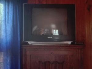 telewizor siedzący na drewnianej szafce w obiekcie Emerald Hill Cabin w mieście Mount Pleasant
